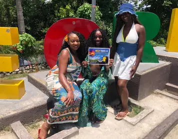 Ritzy Tours JA guests at a colourful Jamaica sign