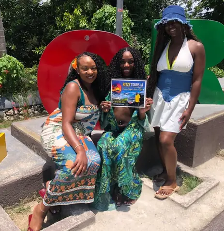 Ritzy Tours JA guests at a colourful Jamaica sign